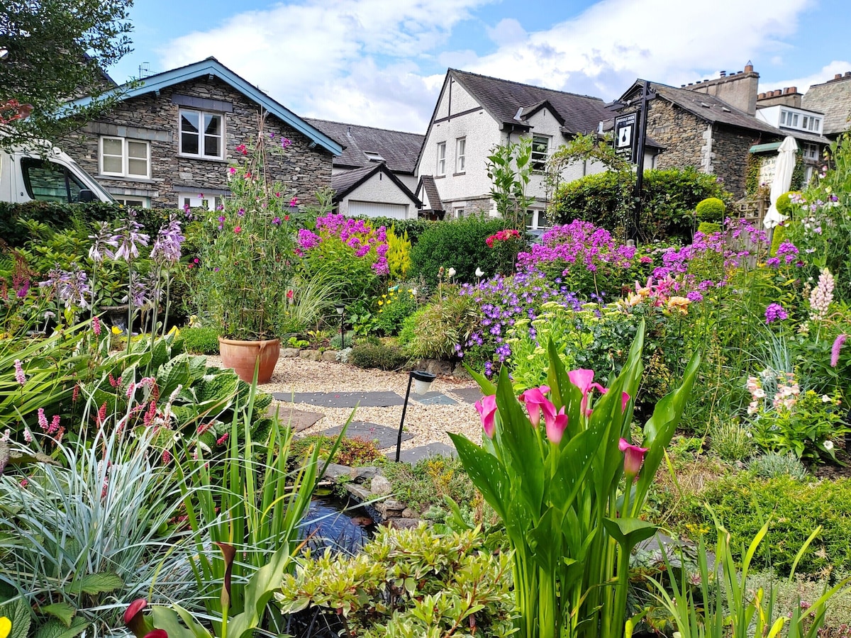 The garden, stone house and pond at Puddle Duck Lodge